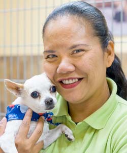 A shelter employee holds an adoptable dog